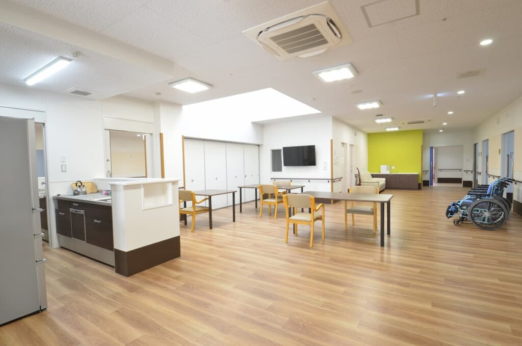 広々とした共用スペース。食事エリアとリビングが一体化し、明るく清潔な施設の雰囲気が伝わる。